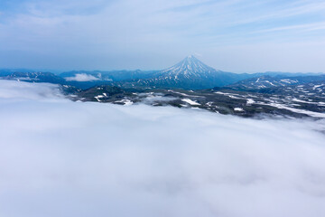 Fototapeta na wymiar Vilyuchinsky Volcano rises above the fog. Kamchatka Peninsula, Russia
