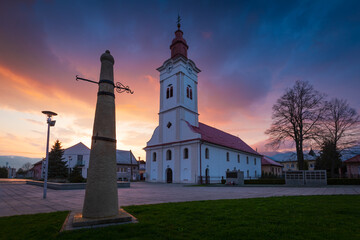 Church and whipping post in the main square of Sucany, Slovakia.