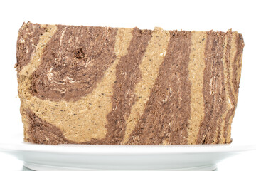 Pieces of sweet halva with chocolate on a white saucer, close-up, isolated on white.