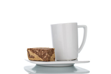 Pieces of sweet halva with chocolate on a white saucer with a white cup, close-up, isolated on white.