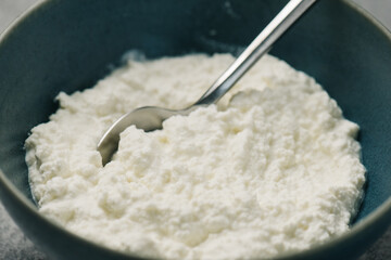 Bowl of fresh homemade ricotta cheese with a spoon