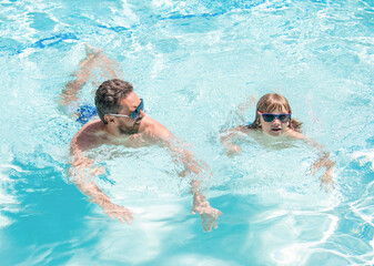 father and son wear glasses in swimming pool water. daddy with kid boy on spa resort