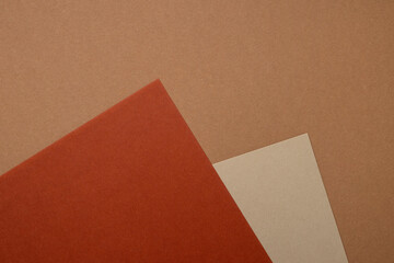 Multi colored abstract paper of pastel beige, orange,brown colors palette, with geometric shape, flat lay.