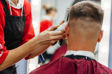 European man is cut by a barber. Men's haircutting with hair clipper