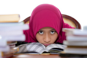 A young female muslim teenager wearing hijab is studying isolated on white background