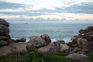 Fototapeta na wymiar Couple at coast with rocks