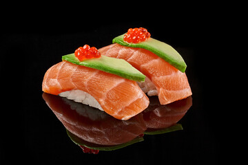 Two nigiri sushi with salmon, avocado, caviar on black background