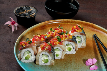 Rolls with mackerel fillet and vegetables on plate with soy sauce