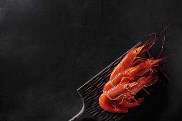 Top view of cooked whole prawns on black background