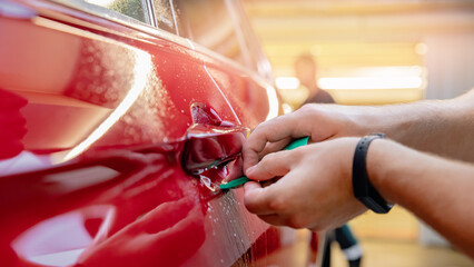 Master installation on in risk zone under handles red car. Paint protection is vinyl film, top view
