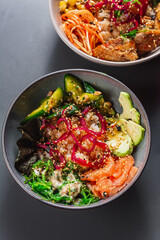 Mix of hawaiiajn Salmon and Tuna poke bowls in colorful bowls wi