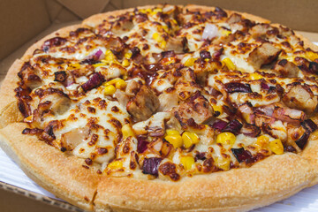 Delicious pizza in a folding cardboard box. Tasty fast food takeout to-go.