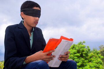 13 year old child with blindfold reading book, on the roof in the rainy season, Indecision and...