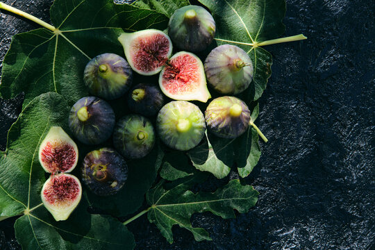 Fresh figs placed on top of green leaves
