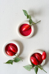 wild rose hip (fruit) arranged in shallow wooden ring containers on speckled paper