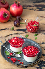 Fresh plain yogurt with pomegranate seeds in a glass jars for breakfast