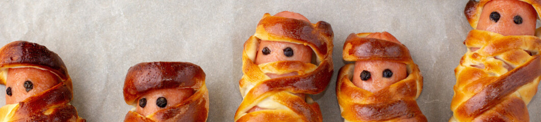 banner of Scary sausage mummies in dough for kids party. Funny crazy Halloween food for children.