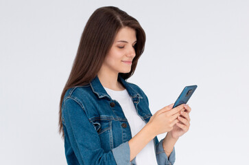 Pleased brunette woman writing message on smartphone over white background