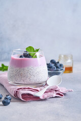 Obraz na płótnie Canvas Chia seeds pudding with blueberry yogurt and fresh berries in glass prepared for healthy breakfast. Selective focus