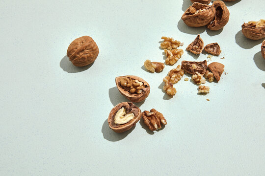 raw cracked walnuts on mint green background