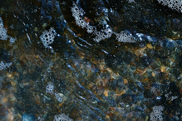 Foam on the water. Dark water.