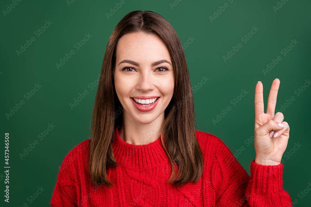 Sticker photo portrait girl in red pullover showing v-sign peace gesture smiling isolated green color backgr