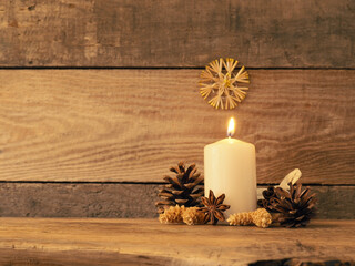 First Advent candle burning on a rustic wooden table