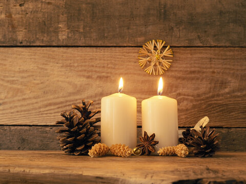 Second Advent candle burning on a rustic wooden table