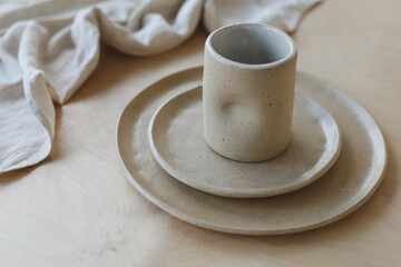 Ceramic plate on a wooden table top view. minimalist handmade ceramic tableware and pottery - obrazy, fototapety, plakaty