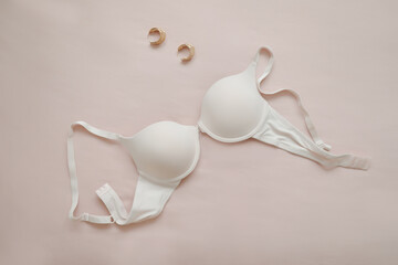 female white lace bra with jewelry on beige background