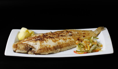 lenguado a la plancha con verduras en fondo negro
