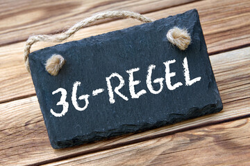 3G-Regel und Schild auf Holz
