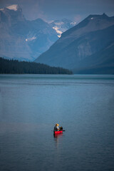 Single person in red canoe on mountain lake