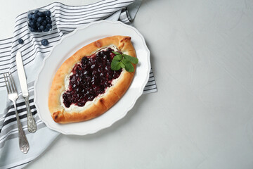 Delicious sweet cottage cheese pastry with cherry jam served on light table, flat lay. Space for text