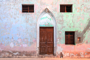 Fototapeta na wymiar Colonial entrance door in weathered building