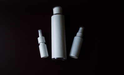 three white bottles on a dark background.