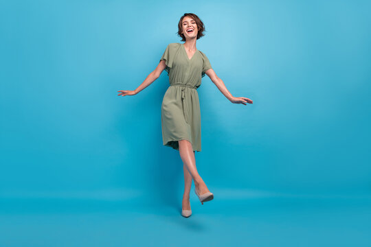 Full size photo of cute young brunette lady dance wear khaki dress stilettos isolated on blue background