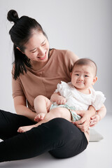 Fototapeta na wymiar Cute Asian baby lying in mother's arms