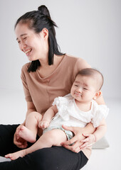 Cute Asian baby lying in mother's arms