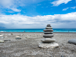 Fototapeta na wymiar Pyramid of sea pebbles on a sunny sand beach in Hualien,Taiwan.
