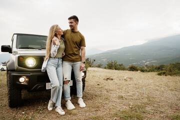 Young couple is on romantic trip to the mountains by car