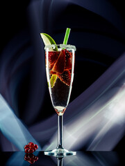 Fruit cocktail with blueberries and strawberries on colorful lights background