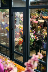 flowers shop refrigerator. Flowers for sale in a special cold room, warehouse with air conditioning. Refrigerator for flowers. Many roses, peony, tulips in florist shop, boutique