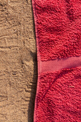 Texture of sand and towel cloth, of intense color, extended to the sun, on Arrigunaga beach, near Bidezabal, Basque Country, Spain