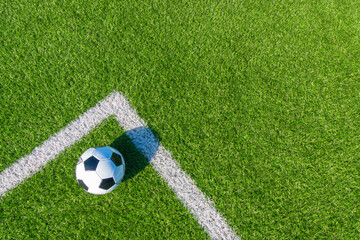 Soccer football sport background. Soccer ball on green artificial grass turf field with white line. Top view
