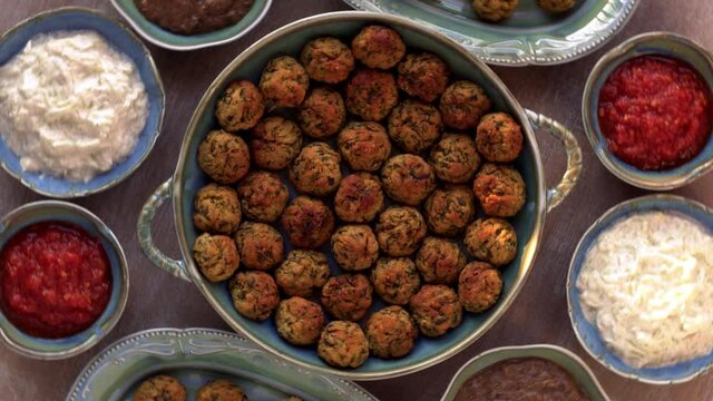 Courgette kofta balls with sides and sauces: tomato dip, rice, mushroom dip and cucumber raita. Indian cuisine.