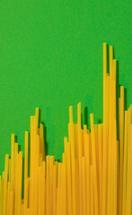 A chart of success made from raw spaghetti on a vibrant green background with copy space. Flat lay minimal arrangement.