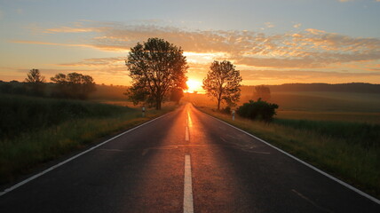 Lange Straße mit Sonnenaufgang rote Sonne