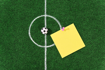Soccer ball in the center of the soccer field and stationery push pins.