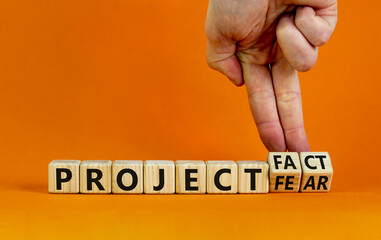 Project fact or fear symbol. Businessman turns cubes, changes words 'project fear' to 'project fact'. Beautiful orange background. Business, ecological and project fact or fear concept. Copy space.